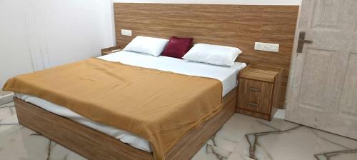 a bedroom with a bed with two red pillows at Heavenly monsoon villa in Devikolam