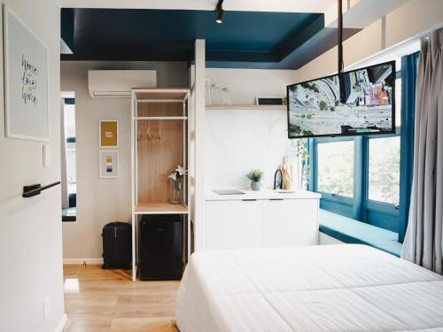 Apê Itaim Bibi - Soft Opening في ساو باولو: غرفة نوم مع سرير وتلفزيون بشاشة مسطحة