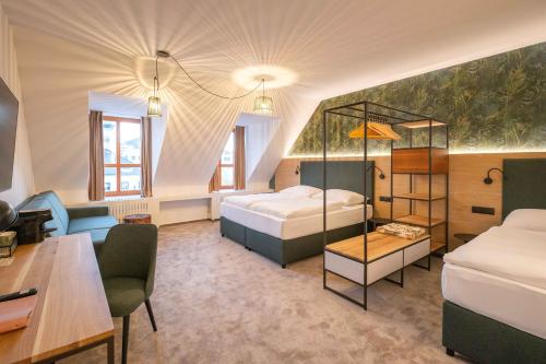 a hotel room with two beds and a desk at Hotel Slovan in Jeseník