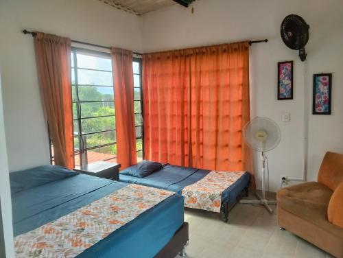 メルガルにあるMelgar Alojamiento Villa Claudiaのベッド2台と窓のある寝室