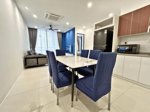 a dining room with a table and blue chairs at Podium 3BR 2BH Modern Homestay Near Aeon in Kuching