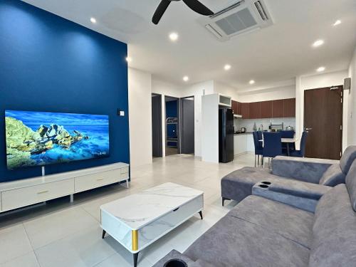 a living room with a large tv on a blue wall at Podium 3BR 2BH Modern Homestay Near Aeon in Kuching