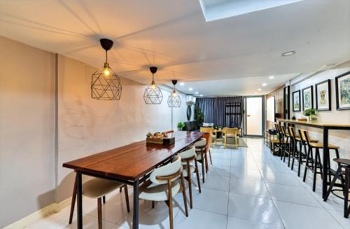a kitchen and dining room with a wooden table and chairs at Bangkok Watergate Townhouse 曼谷中心水門家 in Bangkok