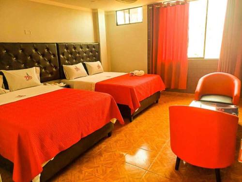 a hotel room with two beds and a chair at Hostal Paris MYP 3 in Lima