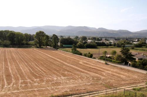 an empty field with mountains in the background at La Colombière - Vue imprenable sur l'Ardèche - Très Calme - Très bien situé - Résidence Privée in Montélimar