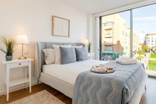 a bedroom with a bed and a large window at Spacious Light-Filled Flat with Garage by HostWise in Leça da Palmeira