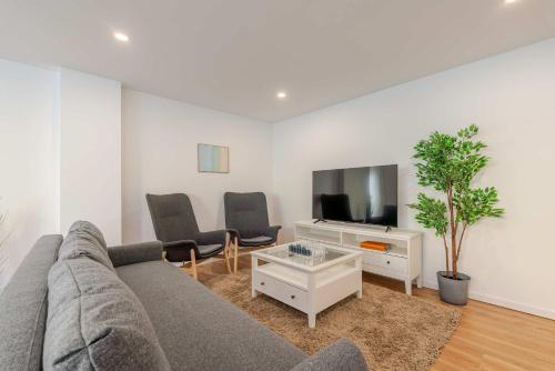 Μια τηλεόραση ή/και κέντρο ψυχαγωγίας στο Spacious Light-Filled Flat with Garage by HostWise