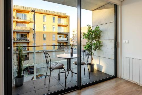 a room with a table and chairs on a balcony at Spacious Light-Filled Flat with Garage by HostWise in Leça da Palmeira