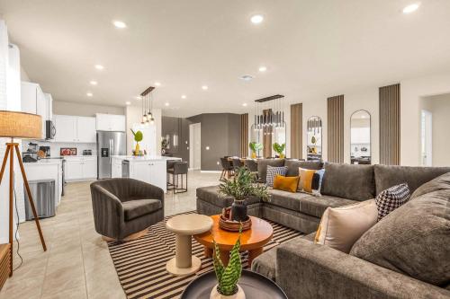 a living room with a couch and a table at Enchanted Clermont Getaway 8BD Villa for groups in Orlando