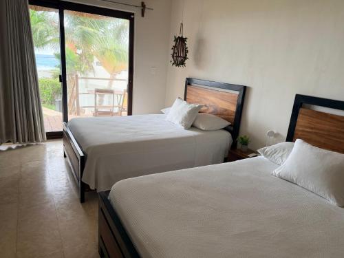 2 letti in una camera con vista sull'oceano di Villa with ocean view, pool, restaurant and rooftop a Isla Mujeres