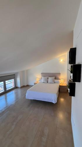 ein Schlafzimmer mit einem großen weißen Bett in einem Zimmer in der Unterkunft Duplex in Bocairent