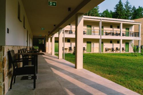 a building with tables and chairs in front of it at PÚŠŤ rekreačné stredisko in Prievidza