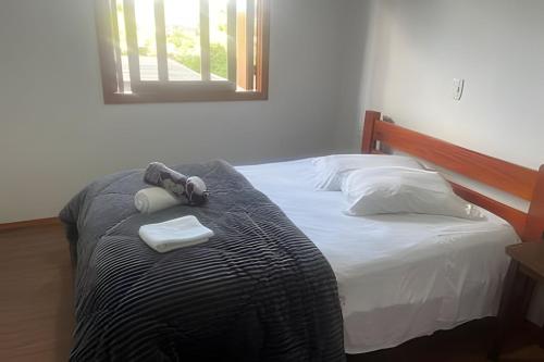 a bedroom with a bed with two towels on it at Casa vista das colinas in Gramado