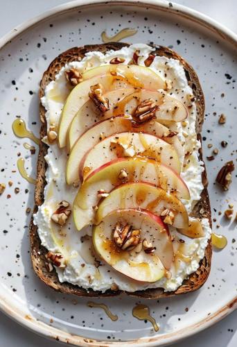 ホーチミン・シティにあるLuxury Eliana Hotelの皿の上にリンゴとナッツが入ったサンドイッチ