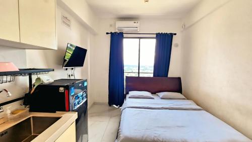 mały pokój z dwoma łóżkami i oknem w obiekcie Apartement Skyhouse Bsd TL26K By LiviRooms Tangerang w mieście Samporo