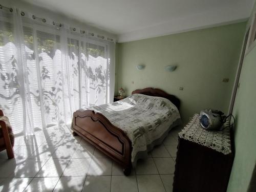 RiaAppartement à Ria-sirach的一间卧室，里面有一张床和一扇大窗户。