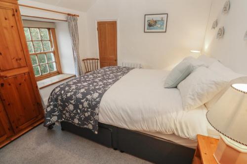 een slaapkamer met een bed en een raam bij 1 Rowes Cottages in Porthcurno