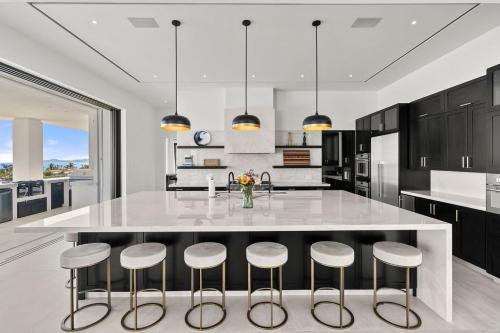 a kitchen with a large white island with bar stools at Poco Paraiso in San José del Cabo