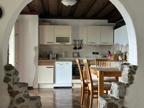 Una cocina con una mesa de madera y una mesa y sillas. en Maem`s Adlerhorst, en Irschen