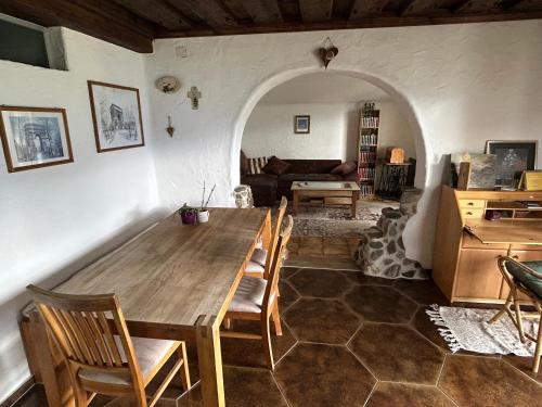 Una sala de estar con una mesa y sillas de madera. en Maem`s Adlerhorst, en Irschen