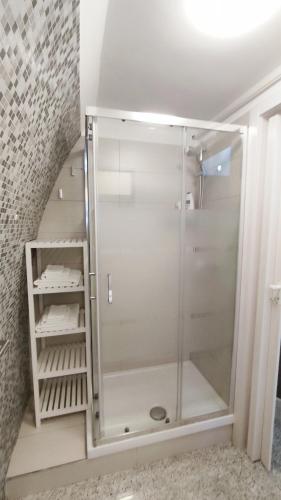 a glass shower in a bathroom with a staircase at B&B Sotto l'Arco nel Cuore del Centro Storico in Gravina in Puglia