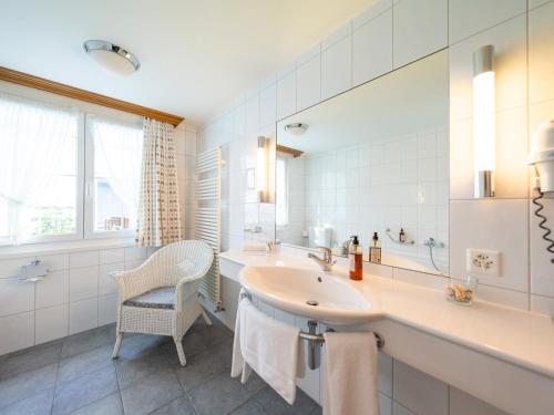 a white bathroom with a sink and a mirror at Hotel Hecht in Appenzell