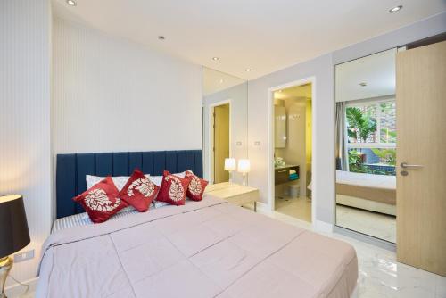 a bedroom with a large bed with red pillows at Pattaya Jomtien Apartments l Guest Friendly l Waterpark Gym Sauna Jacuzzi in Pattaya South