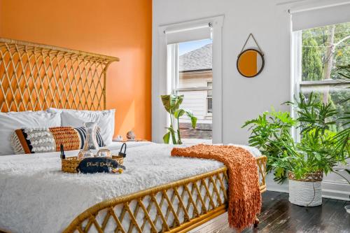 a bedroom with a large bed with an orange wall at Jungle House Columbus Short North Downtown Free Parking - Walk to Convention Center & Nationwide Arena - 4BR Luxury Home - Sleeps 20 - Over 5,800 Five Star Stays in Columbus