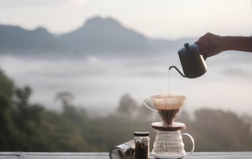 Ban SakoenにあるPhulangcarのテーブルの上のブレンダーで飲み物を作っている人