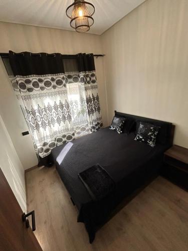 um quarto com uma cama preta num quarto em Résidence Natura Living em Mohammedia