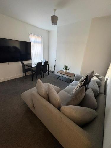 a living room with a couch and a table at Spacious 3-Bedroom Apartment with Modern Comforts in Runcorn