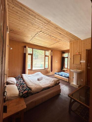 a bedroom with a large bed in a room at Shiva Valley Riverside in Jibhi