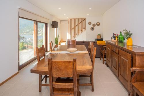 eine Küche und ein Esszimmer mit einem Holztisch und Stühlen in der Unterkunft Casas de São Pedro in Rio Caldo