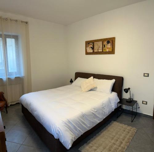 una camera da letto con un letto grande con lenzuola bianche di Elegant apartment near the Sacra- La Casita di Sopra a Caprie