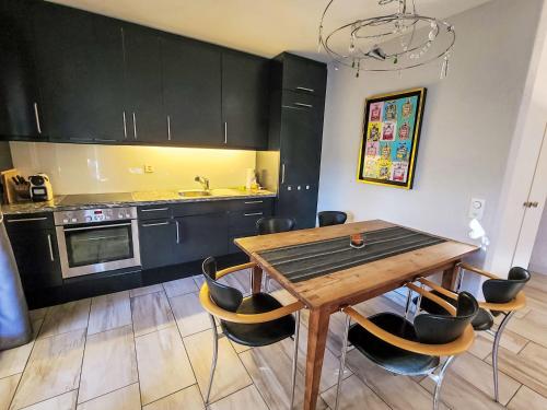 a kitchen with a wooden table and black cabinets at Apartment Collina Verde B by Interhome in Ascona