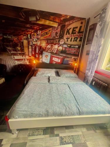 a bed in a room with a wall covered in stickers at König Apartmen in Kynšperk nad Ohří