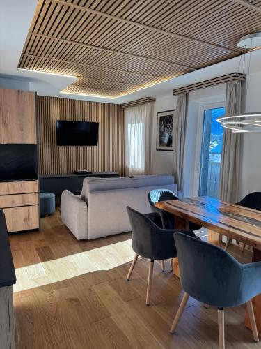 een woonkamer met een tafel en een bank bij Cesa Balzan in Canazei