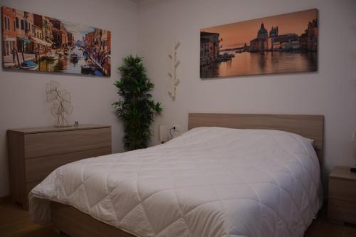 Un dormitorio con una cama y dos cuadros en la pared. en Ca' Serenella, en Venecia