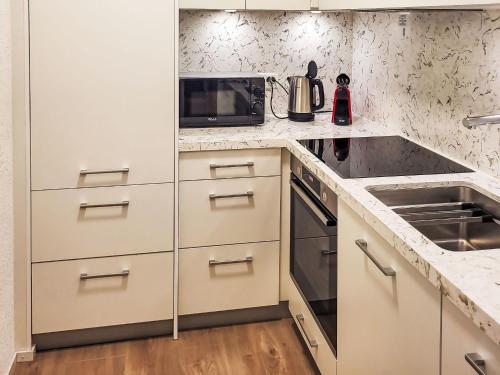 洛伊克巴德Apartment Ringstrasse - Utoring-3 by Interhome的配有白色橱柜和微波炉的厨房