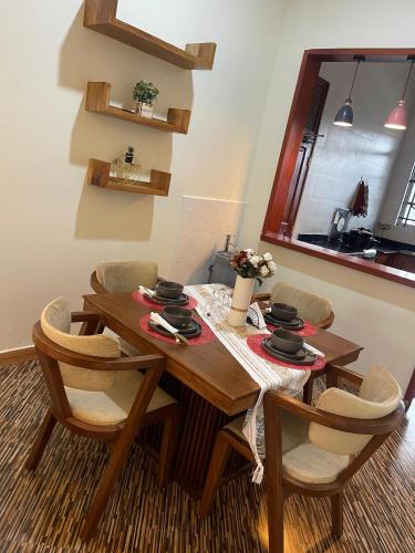 a dining room with a wooden table and chairs at Famurest in Nkoanrua