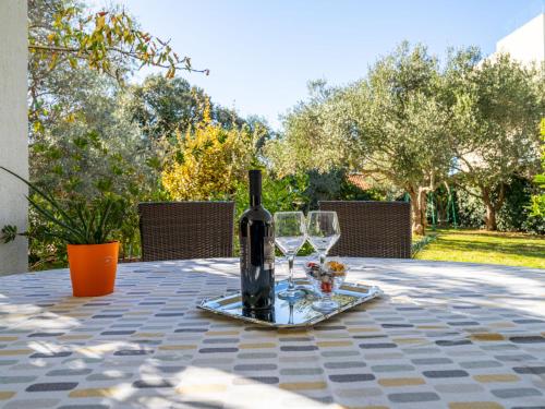 eine Flasche Wein auf einem Tisch mit Brille in der Unterkunft Apartment Anica-1 by Interhome in Zadar