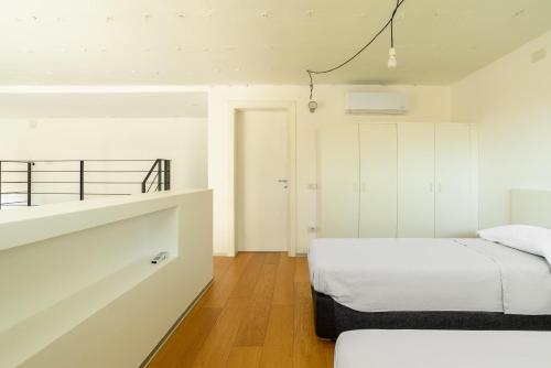 a bedroom with white walls and a bed in it at Loft Kala Zèna in La Maddalena