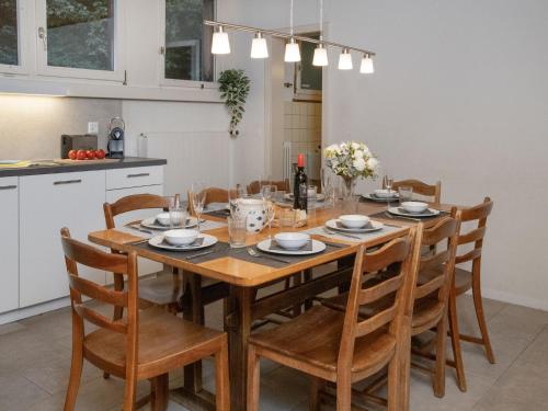 a dining room table with chairs and a kitchen at Apartment Helene Apt-Diana by Interhome in Wengen