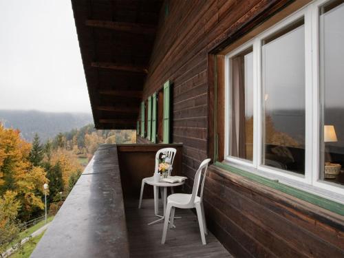 a balcony with two chairs and a table and a window at Apartment Helene Apt-Diana by Interhome in Wengen
