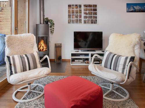 a living room with two chairs and a television at Apartment Racer's Retreat Apt-12 by Interhome in Wengen