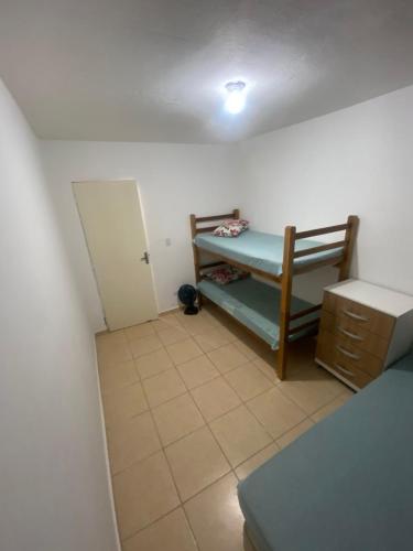 una piccola stanza con un letto e un armadio di Paraíso Montanha e Mar a Peruíbe