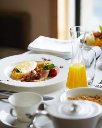 uma mesa com um prato de comida e um copo de sumo de laranja em Ancient Luxury Hotel em Cidade de Ho Chi Minh