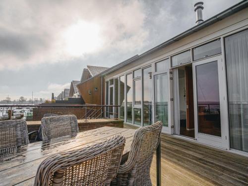 a deck with a wooden table and chairs on a building at Apartment Penthouse by Interhome in Uitgeest