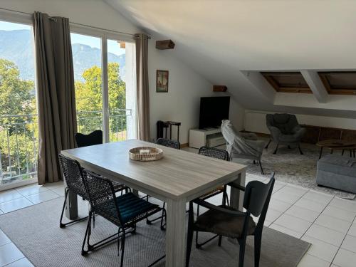 un salon avec une table et des chaises en bois dans l'établissement MALIBAIX, à Aix-les-Bains