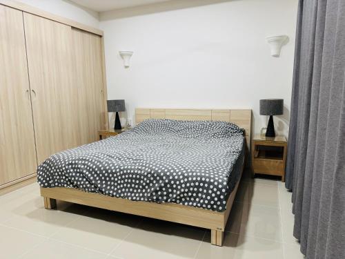 a bedroom with a bed with a black and white comforter at 3BR Pool Villa Beach Access Patumnak Hill in Pattaya South